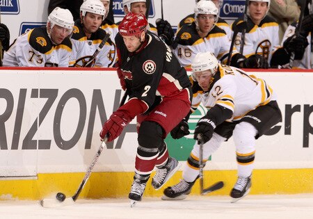 GLENDALE, AZ - OCTOBER 17:  Jim Vandermeer #2 of the Phoenix Coyotes skates with the puck under pressure from Chuck Kobasew #12 of the Boston Bruins during the NHL game at Jobing.com Arena on October 17, 2009 in Glendale, Arizona.  <br /><br /><span class="help">(Photo by Christian Petersen/Getty Images)</span>
