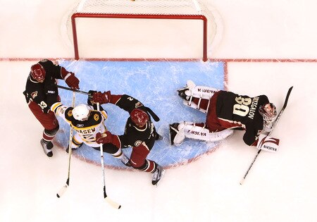 GLENDALE, AZ - OCTOBER 17:  Goaltender Ilya Bryzgalov #30 of the Phoenix Coyotes covers up the puck as Jim Vandermeer #2 and Adrian Aucoin #33 of the Boston Bruins clear out Chuck Kobasew #12 during the NHL game at Jobing.com Arena on October 17, 2009 in Glendale, Arizona. The Coyotes defeated the Bruins 4-1.  <br /><br /><span class="help">(Photo by Christian Petersen/Getty Images)</span>