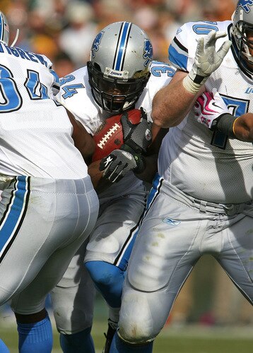 GREEN BAY, WI - OCTOBER 18: Kevin Smith #34 of the Detroit Lions tries to slip between teammates Brandon Pettigrew #84 (L) and Daniel Loper #70 for running room against the Green Bay Packers at Lambeau Field on October 18, 2009 in Green Bay, Wisconsin. The Packers defeated the Lions 26-0. <br /><br /><span class="help">(Photo by Jonathan Daniel/Getty Images)</span>