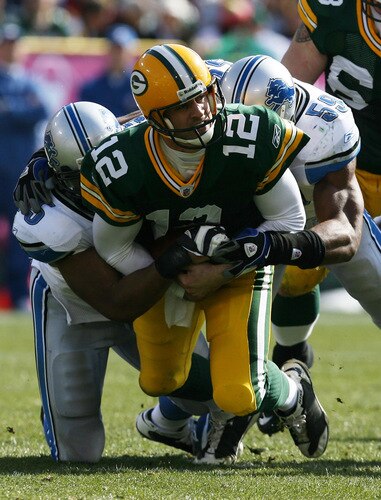 GREEN BAY, WI - OCTOBER 18: Aaron Rodgers #12 of the Green Bay Packers is sacked by Turk McBride #75 and Julian Peterson #59 of Detroit Lions at Lambeau Field on October 18, 2009 in Green Bay, Wisconsin. The Packers defeated the Lions 26-0. <br /><br /><span class="help">(Photo by Jonathan Daniel/Getty Images)</span>