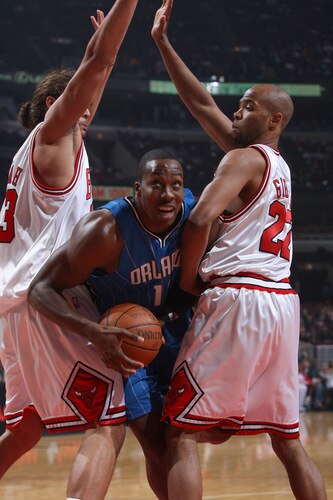 CHICAGO - OCTOBER 19: Dwight Howard #12 of the Orlando Magic attempts to split defenders (L-R) Joakim Noah #13 and Taj Gibson #22 of the Chicago Bulls on the way to the basket during a pre-season game on October 19, 2009 at the United Center in Chicago, Illinois.  <br /><br /><span class="help">(Photo by Gary Dineen/NBAE via Getty Images)</span>
