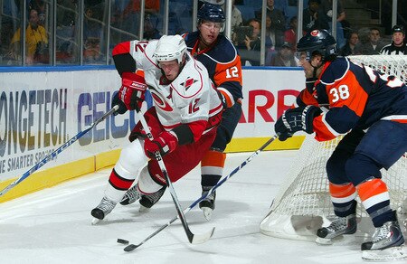UNIONDALE, NY - OCTOBER 21:  Eric Staal #12 of the Carolina Hurricanes tries to control the puck against Josh Bailey #12 and Jack Hillen #38 of the New York Islanders on October 21, 2009 at Nassau Coliseum in Uniondale, New York. The Isles won the game 4-3 after a shoot out.  <br /><br /><span class="help">(Photo by Jim McIsaac/Getty Images)</span>