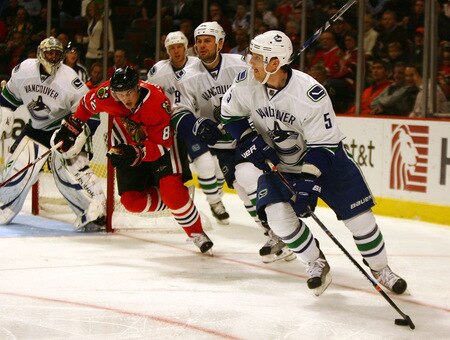 CHICAGO - OCTOBER 21: Christian Ehrhoff #5 of the Vancouver Canucks looks to pass as Tomas Kopecky #82 of the Chicago Blackhawks skates in pursuit at the United Center on October 14, 2009 in Chicago, Illinois. <br /><br /><span class="help">(Photo by Jonathan Daniel/Getty Images)</span>