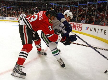CHICAGO - OCTOBER 21: Dustin Byfuglien #33 of the Chicago Blackhawks battles in the corner for the puck with Shane O'Brien #55 of the Vancouver Canucks at the United Center on October 14, 2009 in Chicago, Illinois. <br /><br /><span class="help">(Photo by Jonathan Daniel/Getty Images)</span>