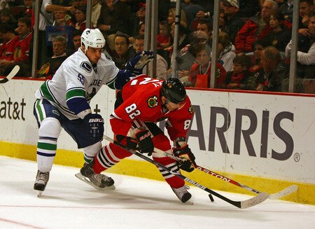 CHICAGO - OCTOBER 21: Tomas Kopecky #82 of the Chicago Blackhawks tries to control the puck under pressure from Shane O'Brien #55 of the Vancouver Canucks at the United Center on October 14, 2009 in Chicago, Illinois. <br /><br /><span class="help">(Photo by Jonathan Daniel/Getty Images)</span>