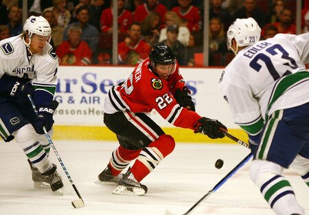 CHICAGO - OCTOBER 21: Troy Brouwer #22 of the Chicago Blackhawks tries to pass the puck between Michael Grabner #40 (L) and Alexander Edler #23 of the Vancouver Canucks at the United Center on October 14, 2009 in Chicago, Illinois. The Canucks defeated the Blackhawks 3-2. <br /><br /><span class="help">(Photo by Jonathan Daniel/Getty Images)</span>