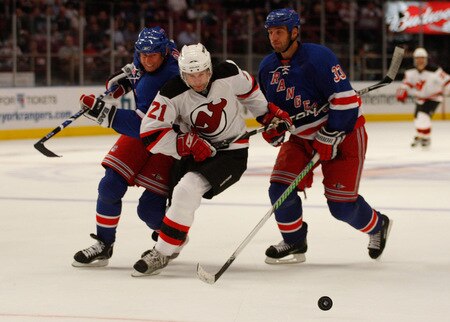 NEW YORK - OCTOBER 22:  Rob Niedermayer #21 of the New Jersey Devils squeezes his way in between Vinny Prospal #20 and Michael Rozsival #33 of the New York Rangers during the game on October 22, 2009 at Madison Square Garden in New York City. <br /><br /><span class="help">(Photo by Jared Wickerham/Getty Images)</span>