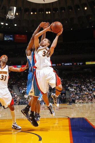 OAKLAND, CA - OCTOBER 22: Stephen Curry #30 of the Golden State Warriors muscles his way for two against the New Orleans Hornets on October 22, 2009 at Oracle Arena in Oakland, California. <br /><br /><span class="help">(Photo by Rocky Widner/NBAE via Getty Images)</span>