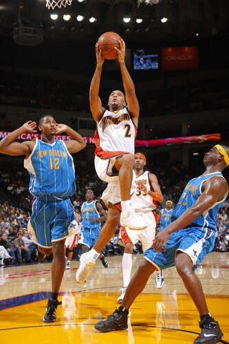 OAKLAND, CA - OCTOBER 22: Acie Law #2 of the Golden State Warriors splits two defenders for a bucket against the New Orleans Hornets on October 22, 2009 at Oracle Arena in Oakland, California. <br /><br /><span class="help">(Photo by Rocky Widner/NBAE via Getty Images)</span>