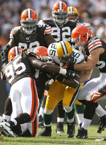 CLEVELAND, OH - OCTOBER 25:  Ryan Grant #12 of the Green Bay Packers fights for yardage as he is hit by Kamerion Wimbley #95 and Jason Trusnik #93 of the Cleveland Browns at Cleveland Browns Stadium on October 25, 2009 in Cleveland, Ohio.  <br /><br /><span class="help">(Photo by Matt Sullivan/Getty Images)</span>