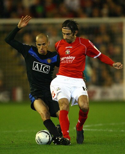 BARNSLEY, ENGLAND - OCTOBER 27:  Daniel Bogdanovic of Barnsley tackles Gabriel Obertan of Manchester United during the Carling Cup 4th Round match between Barnsley and Manchester United at Oakwell on October 27, 2009 in Barnsley, England.  <br /><br /><span class="help">(Photo by Alex Livesey/Getty Images)</span>