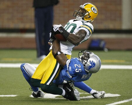 DETROIT , MI - NOVEMBER 26:  Donald Driver #80 of the Green Bay Packers is tackled after catching a first quarter pass by Marvin White #25 the Detroit Lions on November 26, 2009 at Ford Field in Detroit, Michigan. Green Bay won the game 34-12.  <br /><br /><span class="help">(Photo by Gregory Shamus/Getty Images)</span>