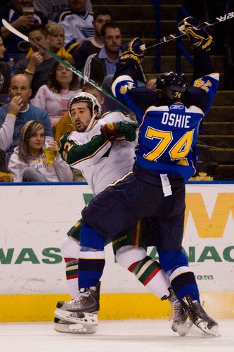 ST. LOUIS, MO - JANUARY 14: TJ Oshie #74 of the St. Louis Blues checks Cal Clutterbuck #22 of the Minnesota Wild at the Scottrade Center on January 14, 2010 in St. Louis, Missouri.  <br /><br /><span class="help">(Photo by Dilip Vishwanat/Getty Images)</span>