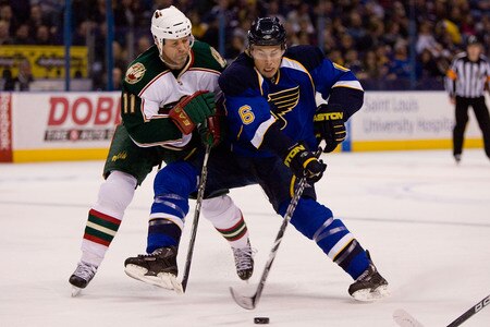 ST. LOUIS, MO. - JANUARY 14: Eric Johnson #6 of the St. Louis Blues controls the puck against Owen Nolan #11 of the Minnesota Wild at the Scottrade Center on January 14, 2010 in St. Louis, Missouri.  <br /><br /><span class="help">(Photo by Dilip Vishwanat/Getty Images)</span>
