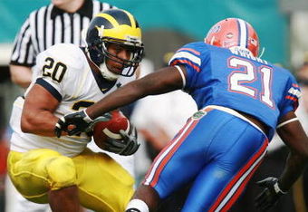 ORLANDO, FL - JANUARY 01:  Running back Mike Hart #20 of the Michigan Wolverines tries to avoid a tackle attempt by safety Major Wright #21of  the Florida Gators in the Capital One Bowl at Florida Citrus Bowl on January 1, 2008 in Orlando, Florida. Michigan defeated Florida 41-35.  (Photo by Doug Benc/Getty Images)