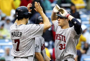 NEW YORK - SEPTEMBER 2:  Justin Morneau #33 of the Minnesota Twins is met at home by teammates Michael Cuddyer #5 and Joe Mauer #5 after hitting a three run home run in the eigth inning against the New York Yankees at Yankee Stadium September 2, 2006 in the Bronx borough of New York City. The Twins defeated the Yankees 6 to 1.  (Photo by Jim McIsaac/Getty Images)              