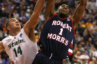 MINNEAPOLIS - MARCH 20: Rob Robinson #1 of the Robert Morris Colonials drives for a shot attempt against Goran Suton #14 of the Michigan State Spartans during the first round of the NCAA Division I Men's Basketball Tournament at the Hubert H. Humphrey Metrodome on March 20, 2009 in Minneapolis, Minnesota. (Photo by Jonathan Daniel/Getty Images)