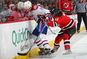NEWARK, NJ - JANUARY 02: John Madden #11 of the New Jersey Devils defends against Tom Kostopoulos #6 of the Montreal Canadiens on January 2, 2009 at the Prudential Center in Newark, New Jersey. (Photo by Bruce Bennett/Getty Images)