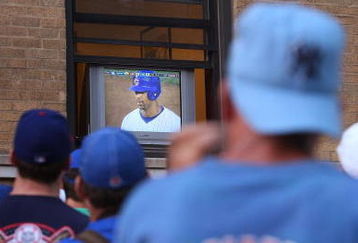 CHICAGO - OCTOBER 6:  Chicago Cubs fans watch the game on a television propped in an apartment window across the street from Wrigley Field as the Chicago Cubs play the Arizona Diamondbacks in the National League Division Series October 6, 2007 in Chicago, Illinois. The Cubs, who have not won a World Series in 99 years, were swept in three straight games by the Diamondbacks.  (Photo by Scott Olson/Getty Images)