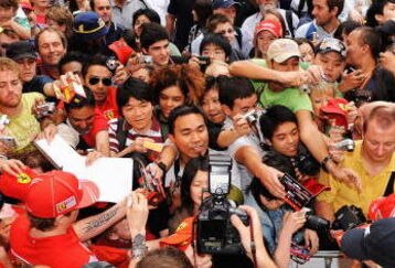 MELBOURNE, AUSTRALIA - MARCH 26:  Kimi Raikkonen of Finland and Ferrari signs autographs for fans at a street parade in the city centre during previews to the Australian Formula One Grand Prix on March 26, 2009 in Melbourne, Australia.  (Photo by Robert Cianflone/Getty Images)