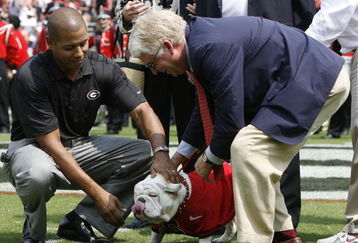 ATHENS - AUGUST 30:  University of Georgia athletic director Damon Evans (L) and school president Michael Adams put a new collar on UGA VII before the game against the Georgia Southern Eagles at Sanford Stadium on August 30, 2008 in Athens, Georgia.  This game is UGA VII's first game as the official school mascot.  (Photo by Mike Zarrilli/Getty Images)