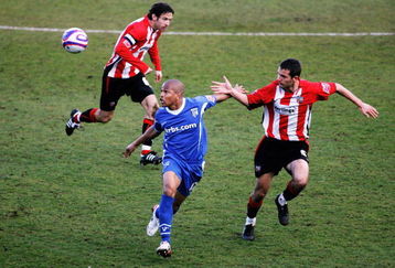 LONDON, ENGLAND - MARCH 28:  Mark Phillips of Brentford (R) tussles with Simeon Jackson of Gillingham during the Coca-Cola League Two match between Brentford and Gillingham at Grifffin Park on March 28, 2009 in London, England.  (Photo by Dean Mouhtaropoulos/Getty Images)