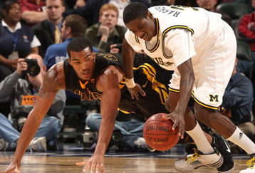 INDIANAPOLIS - MARCH 12:  Manny Harris #3 of the Michigan Wolveriens attempts to control a loose ball against Jarryd Cole #50 of the Iowa Hawkeyes during the first round of the Big Ten Men's Basketball Tournament at Conseco Fieldhouse on March 12, 2009 in Indianapolis, Indiana.  (Photo by Jonathan Daniel/Getty Images)
