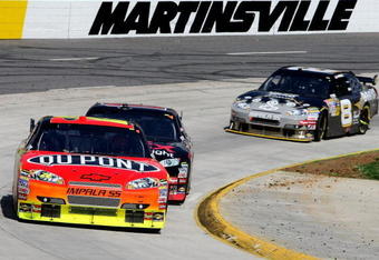 MARTINSVILLE, VA - MARCH 29: Jeff Gordon, driver of the #24 DuPont Chevrolet, leads Denny Hamlin, driver of the #11 FedEx Express Toyota, and Aric Almirola, driver of the #8 Guitar Hero Chevrolet, during the NASCAR Sprint Cup Series Goody's Fast Pain Relief 500 at the Martinsville Speedway on March 29, 2009 in Martinsville, Virginia.  (Photo by Nick Laham/Getty Images)