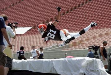 LOS ANGELES - MAY 20:  Wide receiver Travis Wilson #81, the Cleveland Browns third round NFL draft pick, dives with a ball during a trading card shoot at the NFL Players Rookie Premiere Photoshoot on May 20, 2006 at the Los Angeles Memorial Coliseum in Los Angeles, California. (Photo by Paul Spinelli/Getty Images)