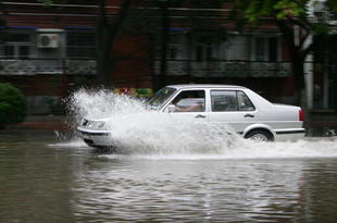 BEIJING, CHINA - AUGUST 10: (CHINA OUT) A car drives through water on a flooded road after heavy rain on August 10, 2008 in Beijing, China. Heavy rain has cooled the city down to about 26 degrees Centigrade today, but also delayed the Olympic tennis competition for about an hour, on the second day of the Olympics. (Photo by China Photos/Getty Images)