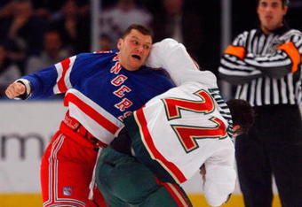 NEW YORK - MARCH 24:  Cal Clutterbuck #22 of the Minnesota Wild fights Sean Avery #16 of the New York Rangers during the first period on March 24, 2009 at Madison Square Garden in New York City.  (Photo by Jim McIsaac/Getty Images)