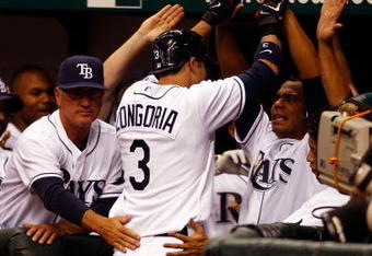 ST. PETERSBURG, FL - APRIL 14: Infielder Evan Longoria #3 of the Tampa Bay Rays is congratulated by his teammates after his seventh inning home run tied the game against the New York Yankees on April 14, 2008 at Tropicana Field in St. Petersburg, Florida. (Photo by J. Meric/Getty Images)