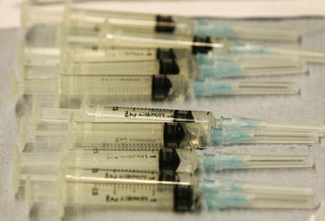 BOLTON, UNITED KINGDOM - MARCH 29:  Syringes are lined up as teams of workers from Bolton Primary Care Trust carry out a mass vaccination exercise on March 29, 2006, Bolton, England. Health officials immunised 1,000 volunteers  in the Bolton Arena as part of the exercise to test the time and logistics of mass immunisation in the event of a flu pandemic. The last flu pandemic was 38 years ago and it's recurrence is every 30-40 years. Volunteers were not actually injected instead an orange was used to simulate the vaccination.  (Photo by Christopher Furlong/Getty Images)