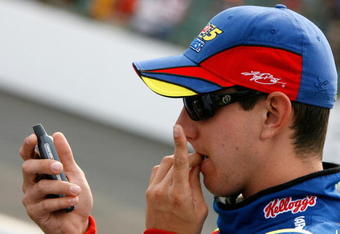 INDIANAPOLIS - JULY 28: Kyle Busch, driver of the #5 Kellogg's/CARQUEST Chevrolet, looks at his cellphone on pit road during qualifying for the NASCAR Nextel Cup Series Allstate 400 at Indianapolis Motor Speedway on July 28, 2007 in Indianapolis, Indiana.  (Photo by Kevin C. Cox/Getty Images)