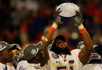 MIAMI - JANUARY 08:  Brandon Spikes #51 of the Florida Gators celebrate with the trophy after defeating the Oklahoma Sooners in the FedEx BCS National Championship Game at Dolphin Stadium on January 8, 2009 in Miami, Florida. The Gators won the game by a score of 24-14.  (Photo by Eliot J. Schechter/Getty Images)