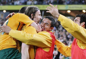 SYDNEY, AUSTRALIA - APRIL 01: Harry Kewell (L) and Tim Cahill (2nd R) of Australia embrace Joshua Kennedy (2nd L) after Kennedy scored a goal during the 2010 FIFA World Cup qualifying match between the Australian Socceroos and Uzbekistan at ANZ Stadium on April 1, 2009 in Sydney, Australia.  (Photo by Mark Nolan/Getty Images)