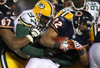 CHICAGO - DECEMBER 22: Matt Forte #22 of the Chicago Bears is tackled by Johnny Jolly #97 and Brandon Chillar #54 of the Green Bay Packers on December 22, 2008 at Soldier Field in Chicago, Illinois. The Bears defeated the Packers 20-17 in overtime.  (Photo by Jonathan Daniel/Getty Images)