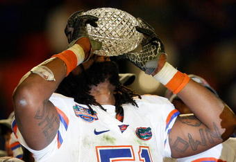 MIAMI - JANUARY 08:  Brandon Spikes #51 of the Florida Gators celebrate with the trophy after defeating the Oklahoma Sooners in the FedEx BCS National Championship Game at Dolphin Stadium on January 8, 2009 in Miami, Florida. The Gators won the game by a score of 24-14.  (Photo by Eliot J. Schechter/Getty Images)