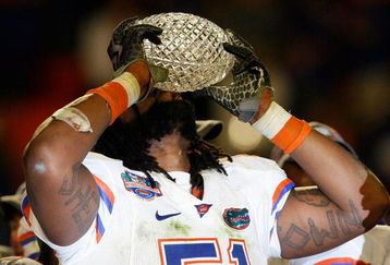 MIAMI - JANUARY 08:  Brandon Spikes #51 of the Florida Gators celebrate with the trophy after defeating the Oklahoma Sooners in the FedEx BCS National Championship Game at Dolphin Stadium on January 8, 2009 in Miami, Florida. The Gators won the game by a score of 24-14.  (Photo by Eliot J. Schechter/Getty Images)
