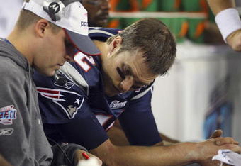 GLENDALE, AZ - FEBRUARY 03:  Quarterback Tom Brady #12 of of the New England Patriots sits on the bench with Offensive Coordinator Josh McDaniels during the fourth quarter of Super Bowl XLII against the New York Giants on February 3, 2008 at the University of Phoenix Stadium in Glendale, Arizona.  (Photo by Donald Miralle/Getty Images)