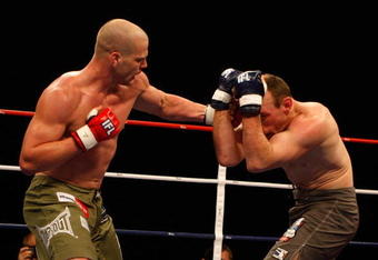 HOFFMAN ESTATES, IL - NOVEMBER 03:  Benji Radach (Green Trunks) of the Anacondas lands a punch against Brent Beauparlant (Gray Trunks) of the Dragons during their Middle weight (185 lb.) bout at the World Grand Prix Semi-Finals at the Sears Centre November 3, 2007 in Hoffman Estates, Illinois. Radach won by KO in the first round. (Photo by Ross Dettman/Getty Images for IFL)