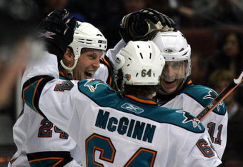 ANAHEIM, CA - MARCH 15:  Travis Moen #24 of the San Jose Sharks celebrates his second period goal with teammates Jamie McGinn #64 and Marcel Goc #11 during the NHL game against the Anaheim Ducks at Honda Center on March 15, 2009 in Anaheim, California.  (Photo by Victor Decolongon/Getty Images)