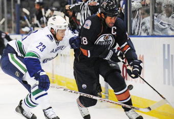 EDMONTON, AB - SEPTEMBER 22:  Alexander Edler #23 of the Vancouver Canucks poke checks the puck from the stick of Ethan Moreau #18 of the Edmonton Oilers during an NHL preseason game on September 22, 2008 at Rexall Arena in Edmonton, Canada. The Canucks defeated the Oilers 4-3 in shootout overtime. (Photo by Jimmy Jeong/Getty Images)