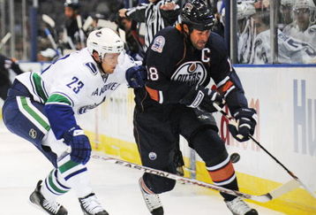 EDMONTON, AB - SEPTEMBER 22:  Alexander Edler #23 of the Vancouver Canucks poke checks the puck from the stick of Ethan Moreau #18 of the Edmonton Oilers during an NHL preseason game on September 22, 2008 at Rexall Arena in Edmonton, Canada. The Canucks defeated the Oilers 4-3 in shootout overtime. (Photo by Jimmy Jeong/Getty Images)
