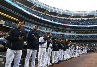 NEW YORK - APRIL 03:  New York Yankees players wait for the playing of the national anthem prior to the start of their game againstthe Chicago Cubs on April 3, 2009 at Yankee Stadium in the Bronx borough of New York City. The exhibition game is the first game to be played at the new Yankee Stadium.  (Photo by Chris McGrath/Getty Images)