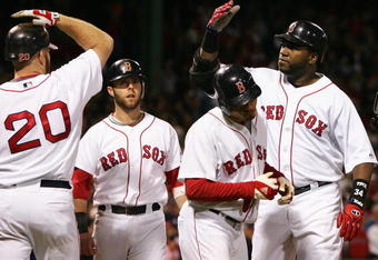 BOSTON - OCTOBER 16:  David Ortiz #34 of the Boston Red Sox is congratuled by teammates Kevin Youkilis #20, Dustin Pedroia #15 and Jed Lowrie #12 after Ortiz hit a 3 run home run against the Tampa Bay Rays in the seventh inning of game five of the American League Championship Series during the 2008 MLB playoffs at Fenway Park on October 16, 2008 in Boston, Massachusetts.  (Photo by Jim McIsaac/Getty Images)