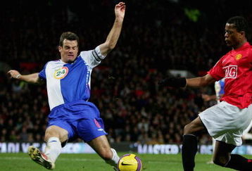 MANCHESTER, UNITED KINGDOM - NOVEMBER 11:   Ryan Nelsen of Blackburn Rovers stretches to block the shot on goal of Patrice Evra of Manchester United during the Barclays Premier League match between Manchester United and Blackburn Rovers at Old Trafford on November 11, 2007 in Manchester, England. (Photo by Jamie McDonald/Getty Images)