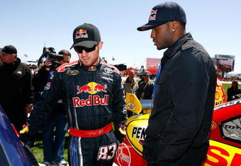 FORT WORTH, TX - APRIL 05:  Brian Vickers (L), driver of the #83 Red Bull Toyota, talks with running back Reggie Bush #25 of the New Orleans Saints on the grid prior to the start of the NASCAR Sprint Cup Series Samsung 500 at Texas Motor Speedway on April 5, 2009 in Fort Worth, Texas.  (Photo by Jason Smith/Getty Images for NASCAR)