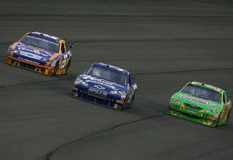 FONTANA, CA - FEBRUARY 22:  Jamie McMurray (L), driver of the #26 Crown Royal Ford, John Andretti (C), driver of the #34 WindowWorld.com Chevrolet, and Kyle Busch (R), driver of the #18 Interstate Batteries Toyota, drive during the NASCAR Sprint Cup Series Auto Club 500 at Auto Club Speedway on February 22, 2009 in Fontana, California.  (Photo by Jeff Gross/Getty Images)