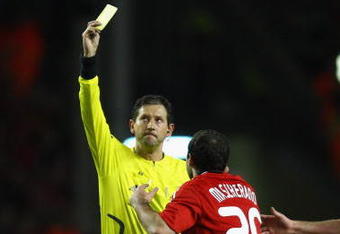 LIVERPOOL, UNITED KINGDOM - MARCH 10:  Referee Frank De Bleeckere shows a yellow card to Javier Mascherano of Liverpool during the UEFA Champions League Round of Sixteen, Second Leg match between Liverpool and Real Madrid at Anfield on March 10, 2009 in Liverpool, England. (Photo by Clive Mason/Getty Images)